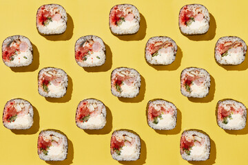 Sushi rolls pattern on yellow background.