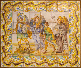 VALENCIA, SPAIN - FEBRUARY 14, 2022: The ceramic mosaic of Archangels - Michael, Gabriel and Raphael on the facade of church Basilica de la Mare de Deu dels Desamparats.