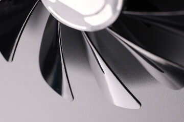 Cooling fan with plastic black blades on grey background