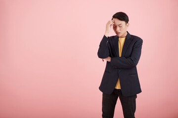Stressed young businessman thinking how to solve problem, isolated on pink
