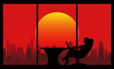silhouette of a woman sitting in an armchair at a table in an office with large windows against the backdrop of skyscrapers and the evening sun on a red sky