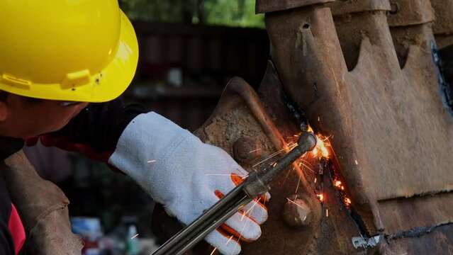 Worker cutting steel with a gas torch. Man cutting steel with propane and oxygen. Processes that use fuel gases and oxygen to weld and cut metals.
