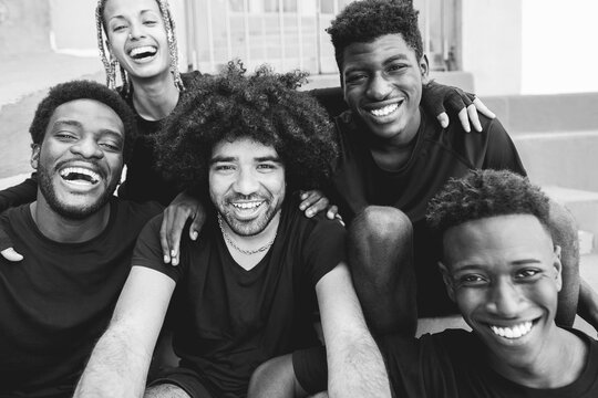 African friends doing selfie with mobile phone outdoor - Focus on center man face - Black and white editing
