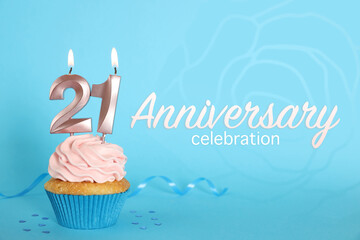 Delicious cupcake with number shaped candles on light blue background. Coming of age party - 21th birthday. Anniversary celebration