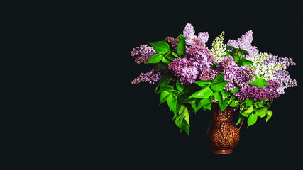 Bouquet of lilacs of different colors in a clay jug