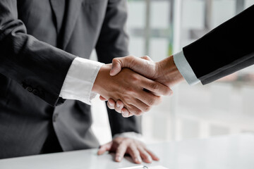 The salesperson of the housing estate in the project and the customer shake hands after successfully signing the contract. Concept of selling housing estates and real estate.