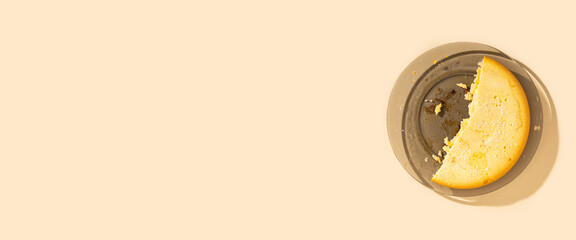 Half of the pie on a plate on a beige background. Top view, flat lay. Banner.