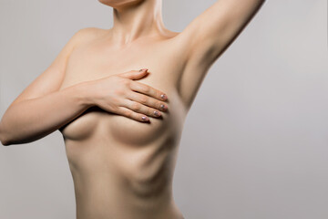Beautiful girl with a beautiful body. Woman with breast pain touching chest.  Female healthcare concept.