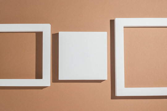White square podiums for presentations on a brown background. Top view, flat lay