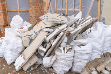 Building debris from the dismantled facade coating. Construction waste in white bags on the street