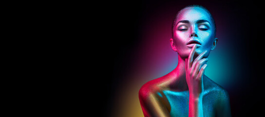 Fashion art portrait. Model girl in colorful bright sparkles and neon lights posing in studio,...