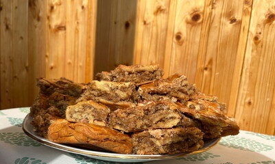 Baklava is a dessert made with layers upon layers of butter brushed phyllo dough with cinnamon scented walnuts in the middle. Pakhlava slices closeup