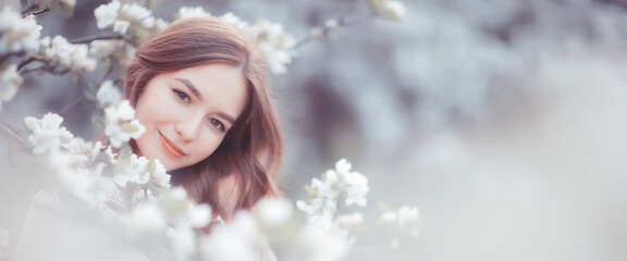 springtime fashion portrait of a young girl in a blooming cherry garden, tenderness of the morning