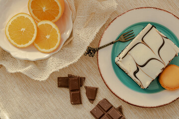 Brownies with chocolate and fresh oranges slices , blocks of black chocolate ,vintage fork, plate , dessert 