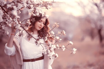 Fototapeta premium happy girl dreaming in a blooming garden, fresh tenderness spring woman in flowers
