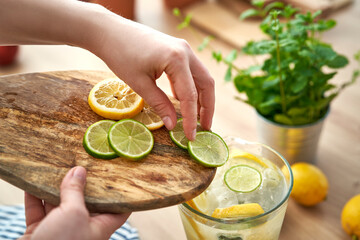 High angle view of  unrecognizable person making homemade lemonade with fresh citrus