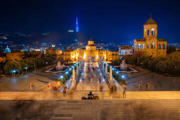 People traces in long exposure. View of Tsminda Sameba Gate and bell tower, Trinity Church for Easter night, Tbilisi, Georgia. - 500889344