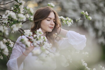 happy girl dreaming in a blooming garden, fresh tenderness spring woman in flowers