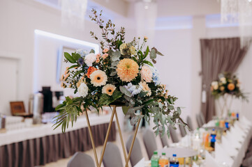 Stół przyozdobiony kwiatami na imprezie weselnej