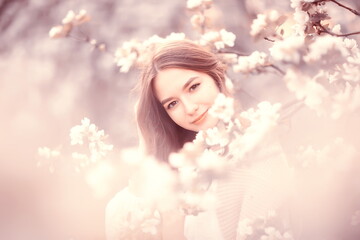 springtime fashion portrait of a young girl in a blooming cherry garden, tenderness of the morning