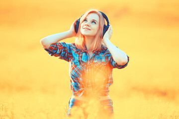 audio headphones summertime girl music in a field of flowers, young female spring