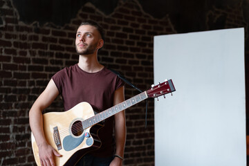 Man with acoustic guitar standing near whiteboard Music school concept