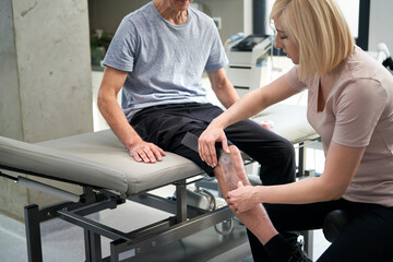 Close up of female physical therapist working with her patient
