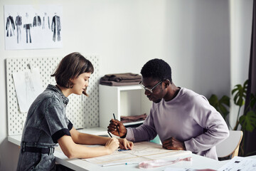 Diverse team of garment designers creating new sewing patterns for upcoming collection