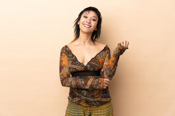 Indian woman isolated on beige background laughing