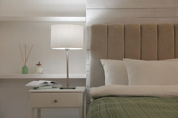 Fototapeta na wymiar Stylish night lamp on bedside table in bedroom