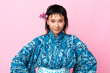 Young woman wearing kimono over isolated pink background