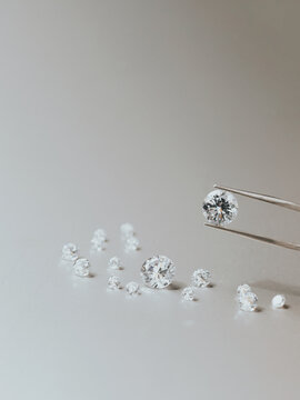 A round brilliant cut diamond held in tweezers