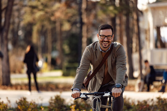 Portrait of a smiling man, riding a bike, looking at the camera.