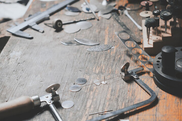 Different goldsmiths tools on the jewelry workplace. Jeweler at work in jewelry. Desktop for craft...