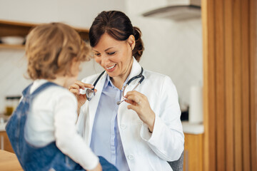 Female pediatrician with her little patient, showing off her ste - obrazy, fototapety, plakaty