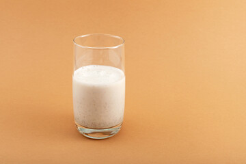 Protein shake made from milk and fried multi-grain powder. Energy drink. Multigrain cocktail in tall clear glass