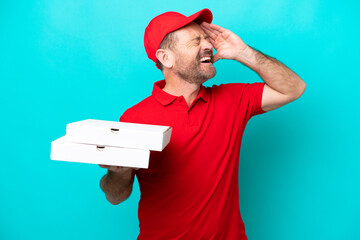 Pizza delivery man with work uniform picking up pizza boxes isolated on blue background smiling a...