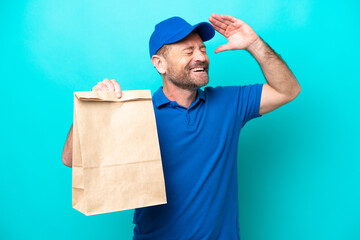Middle age man taking a bag of takeaway food isolated on blue background smiling a lot