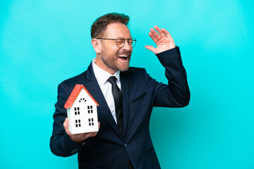 Real estate middle age agent man isolated on blue background smiling a lot