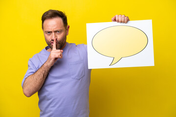 Middle age caucasian man isolated on yellow background holding a placard with speech bubble icon doing silence gesture