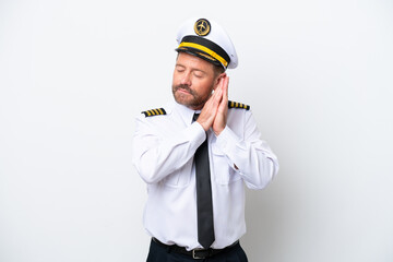Airplane middle age pilot isolated on white background making sleep gesture in dorable expression