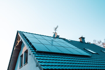 Large solar panels on rooftop of modern comfortable house or cottage. 