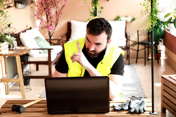 
Worker in his work area with a computer, gloves and a mallet hammer