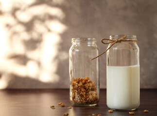fermented milk product kefir in a glass jar with granola on a beige background
