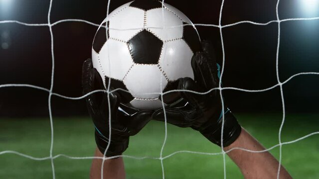 Goalkeeper catches soccer ball, close up, slow motion at 1000 fps. Filmed on high speed cinematic camera.
