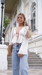 Young sexy beautiful woman with blonde dreadlocks  walking on the street. Close up portrait bohemian girl in white blouse and jewels hippie style. Smiling girls portrait. Traveling 