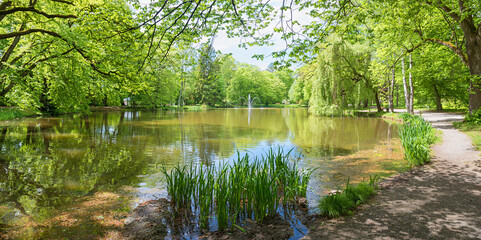 walkway around idyllic pond, Irlacher Weiher, spa garden Bad Aibling at springtime