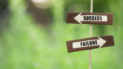 Success - Failure on a wooden signpost on a natural green background.copy space.