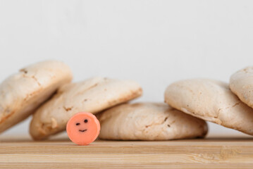 Meringue on a wooden board in the background. Meringue with cocoa. Smiley. Candy.