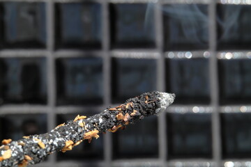 Incense burning against black background - obrazy, fototapety, plakaty